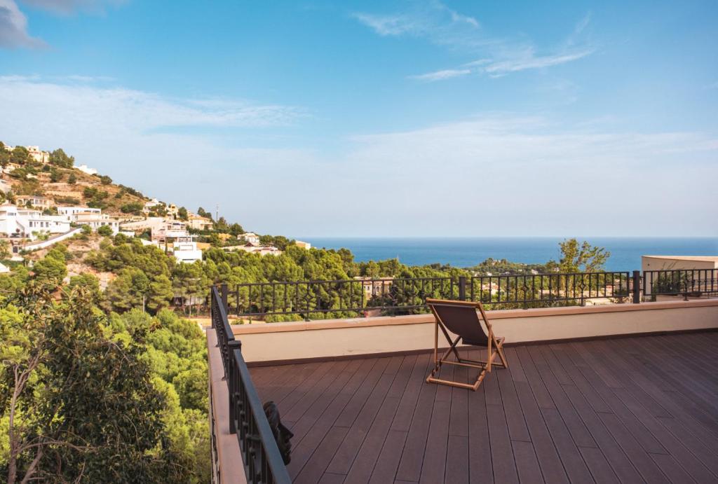a chair on a balcony with a view of the ocean at Bello Horizonte in Altea