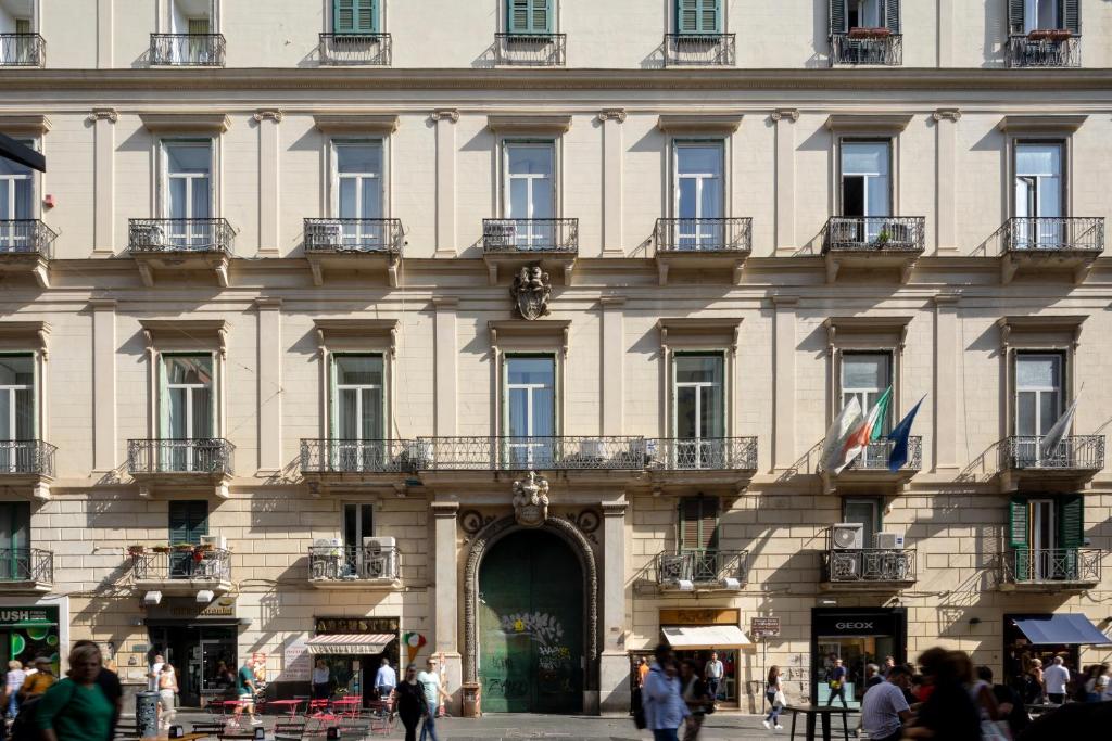 un gran edificio con gente caminando delante de él en Napolit'amo Hotel Principe, en Nápoles