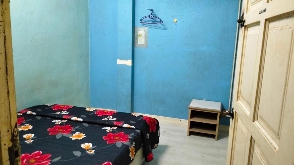 um quarto com uma cama e uma parede azul em Hostel Dena moon inn 3 em Kota Bharu
