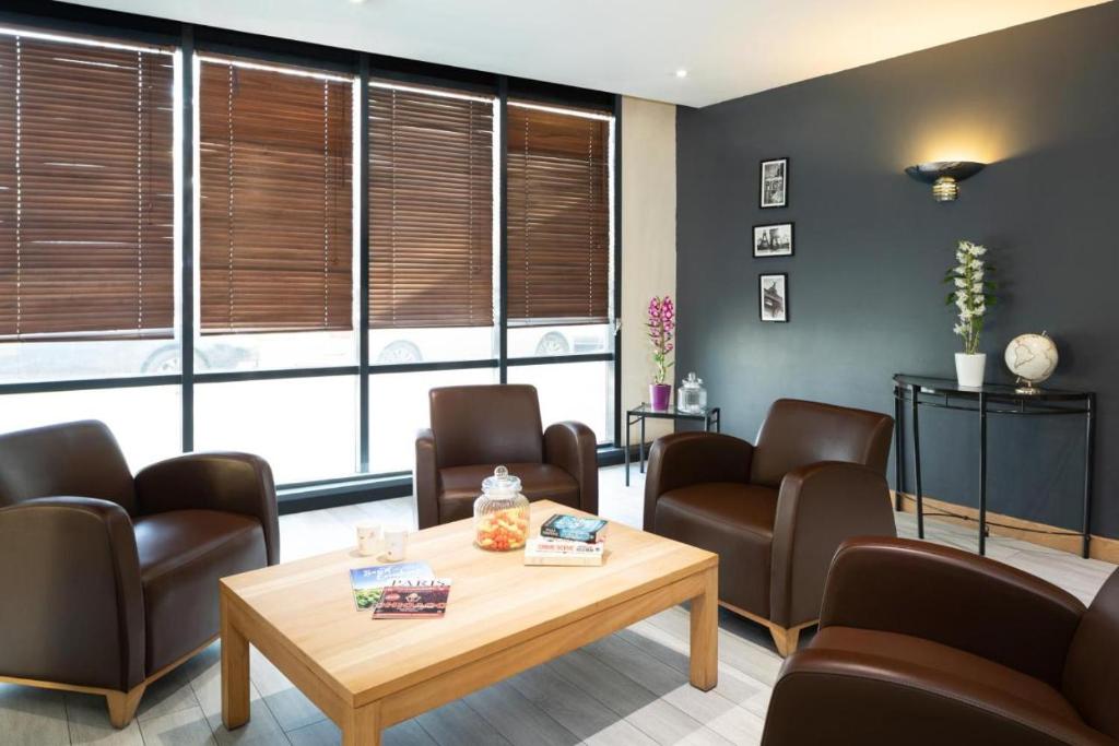 a waiting room with chairs and a table at Appartement Privé La Défense Paris in Courbevoie