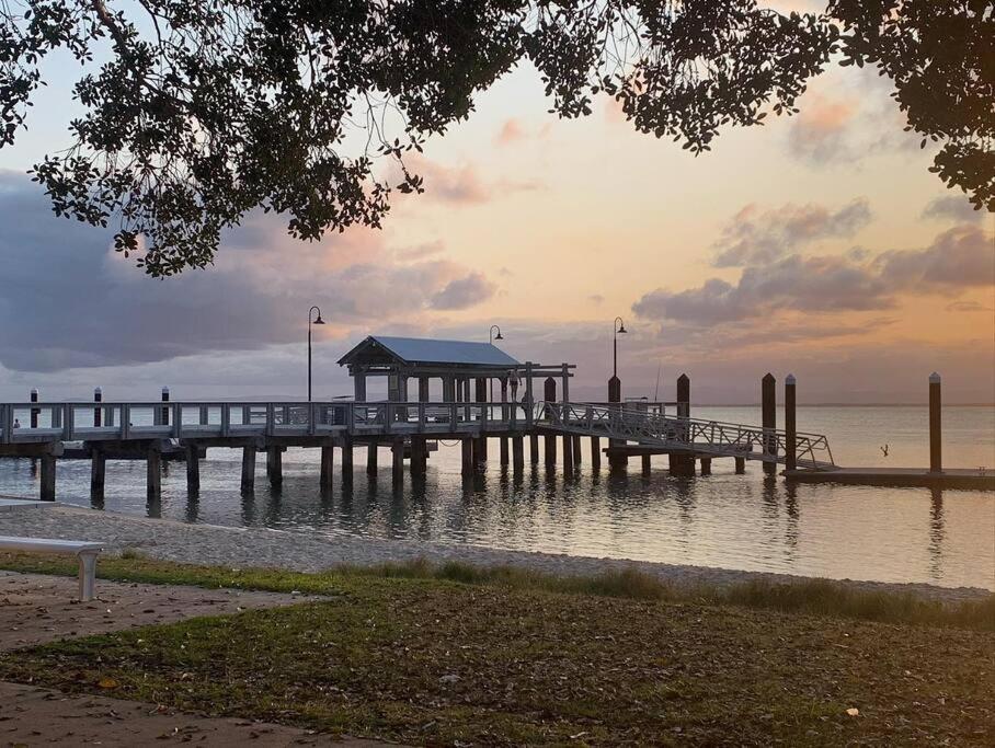 a pier on the water with a building on it at Bribie Get away in Bongaree