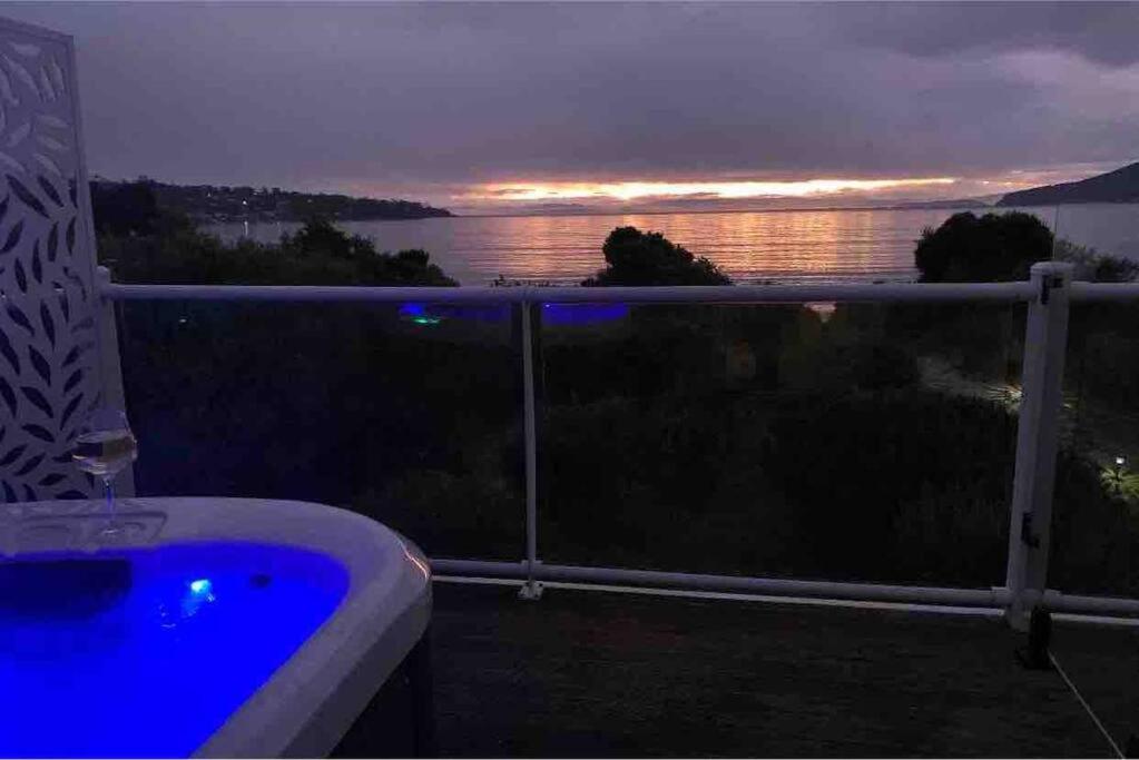 een bad op een balkon met uitzicht op de oceaan bij Beachfront House - Hot Tub, Ocean Views, Private Beach Pathway in White Beach