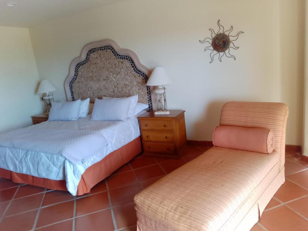 a bedroom with two beds and a chair in it at delfines 204 in Cabo San Lucas