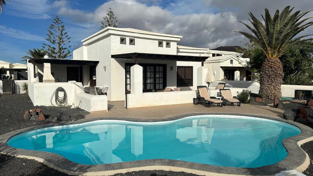dom z basenem przed nim w obiekcie Casa Sophia w mieście Playa Blanca