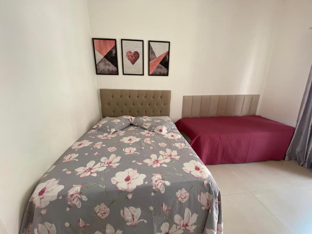 a bedroom with a bed with a flowery comforter at Apto Santos Gonzaga in Santos