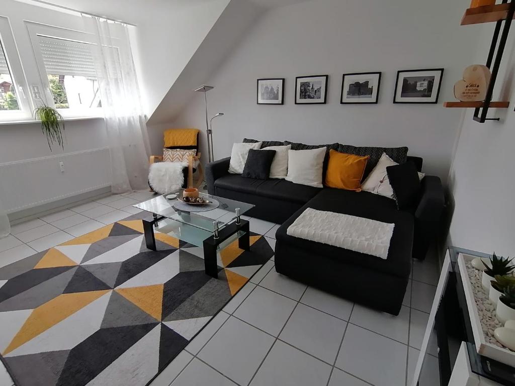 a living room with a black couch and a table at Ferienwohnung Grete in Trier