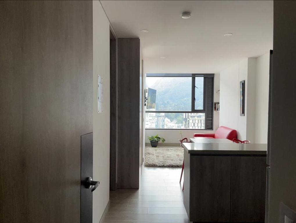 un couloir avec une cuisine et un salon avec une fenêtre dans l'établissement Apartamentos Centro Bogotá piso 16 y o piso 23 -Vista Monserrate, à Bogotá