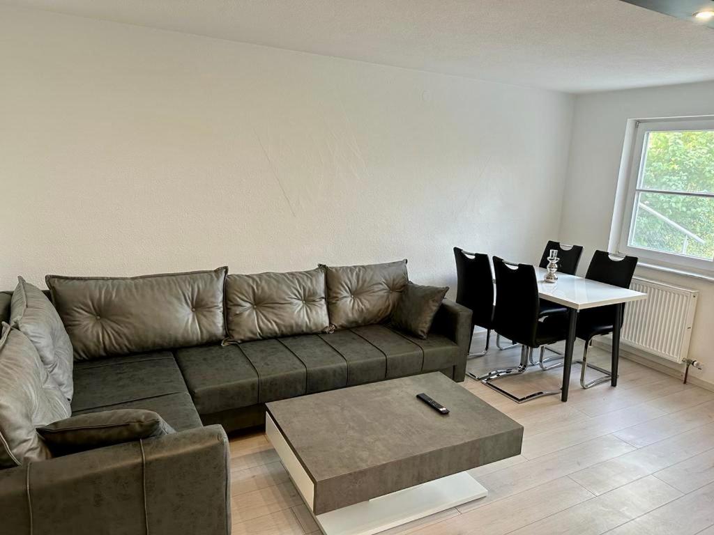 a living room with a couch and a table at flexible, schöne und gut aussehende Feriensuite (für Stadtliebhaber, Shopper, Naturliebhaber und Entspannungssuchende) in Reutlingen