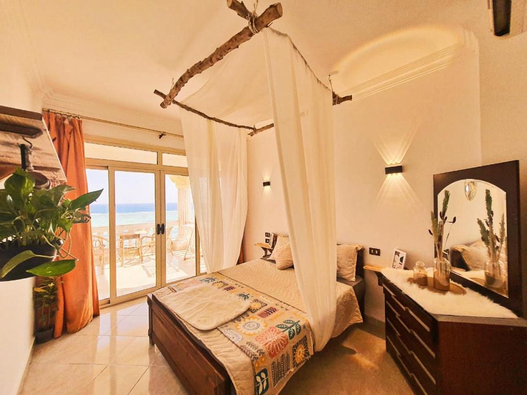 Lucky palace Dahab في دهب: غرفة نوم مع سرير مظلة مع إطلالة على المحيط