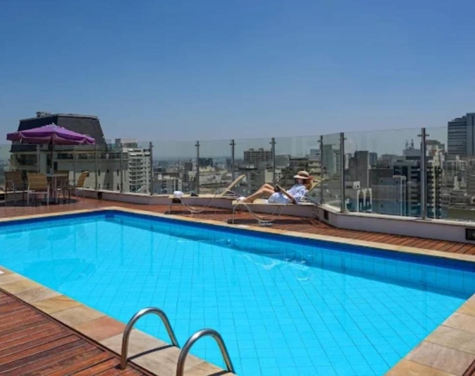 a swimming pool on the roof of a building at Apartamento Charmoso Paulista - By Palm Rooms in Colombo