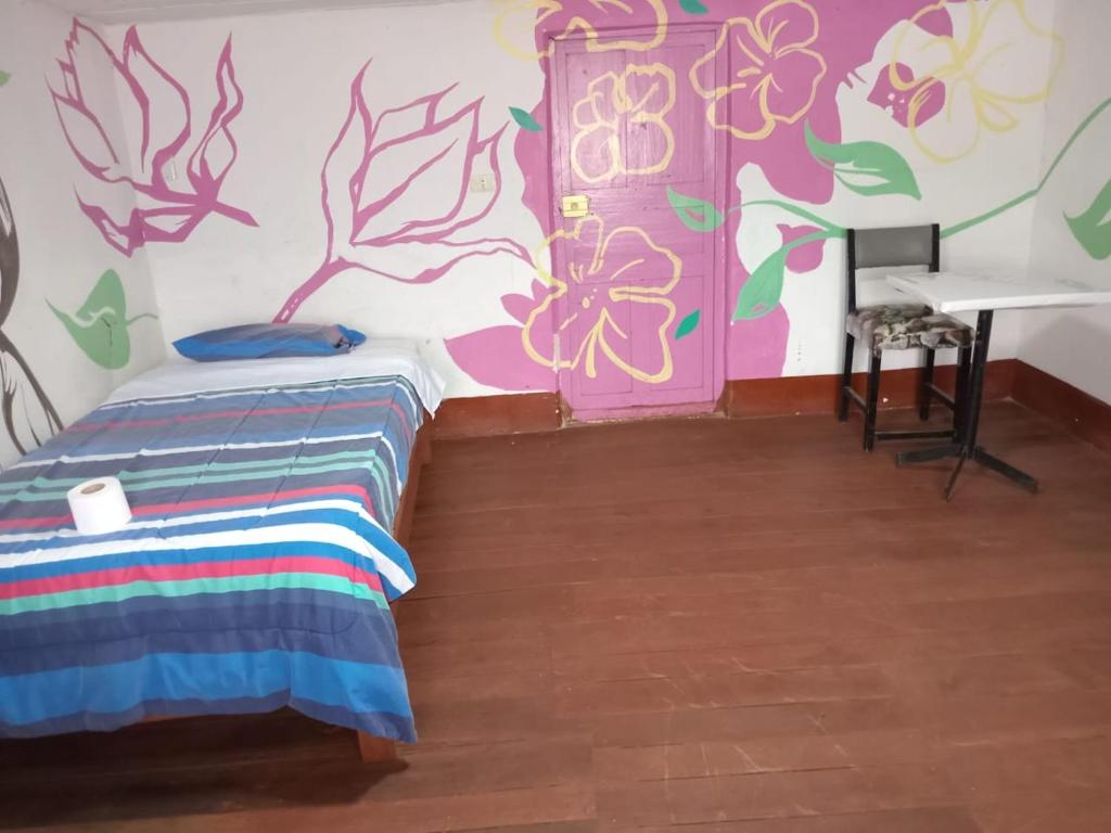 a room with a bed and a wall with flowers at DEJAVU in Chachapoyas