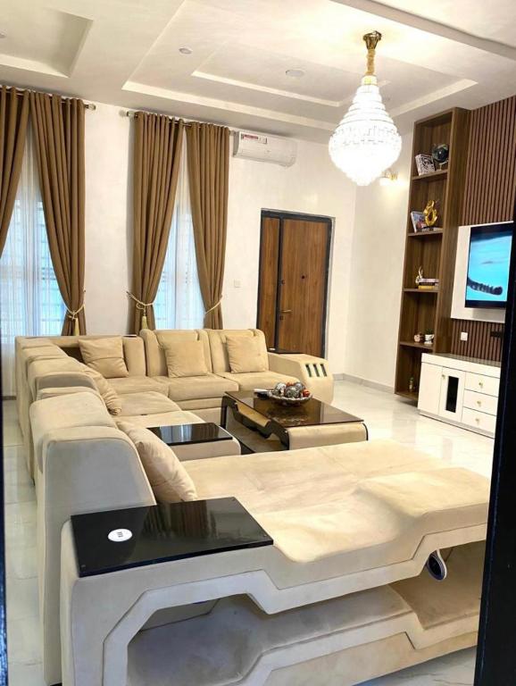 a living room with a couch and a tv at Urban Retreat Luxury Shortlet Apartment Lekki Lagos in Lekki