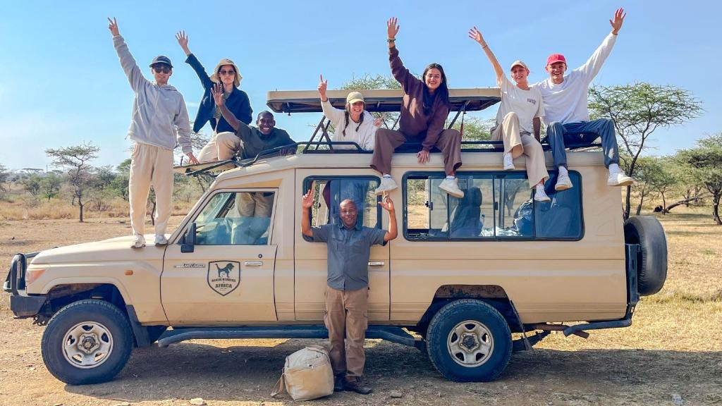 a group of people sitting on the top of a van at we are one apartment in Arusha