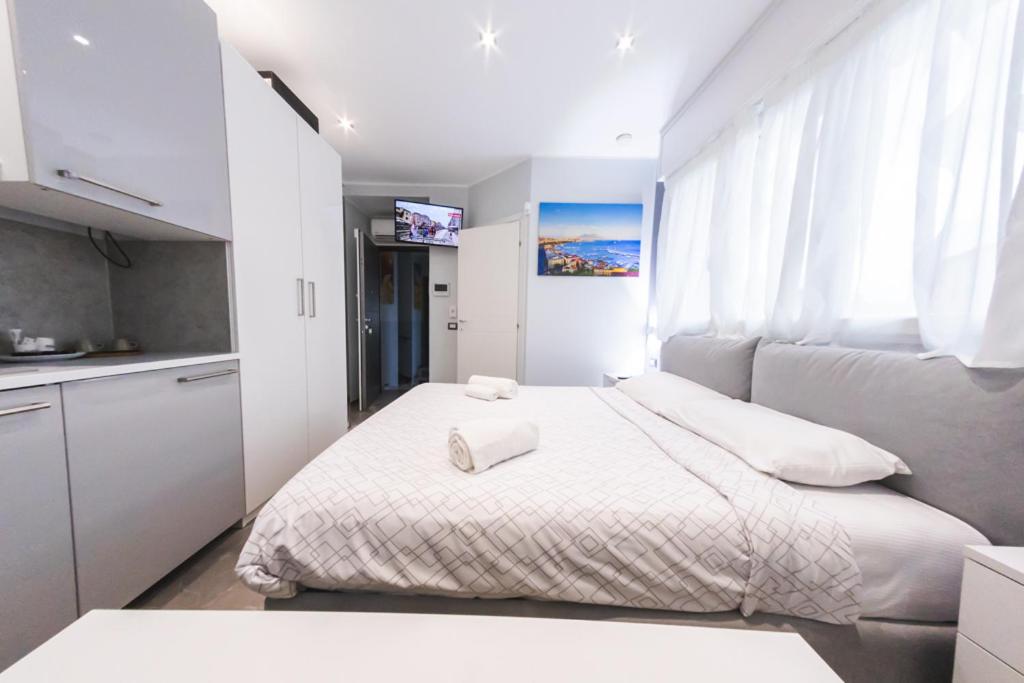 een witte slaapkamer met een bed en een raam bij Residenza Gioiello - Comfort & Suites a Milano in Milaan