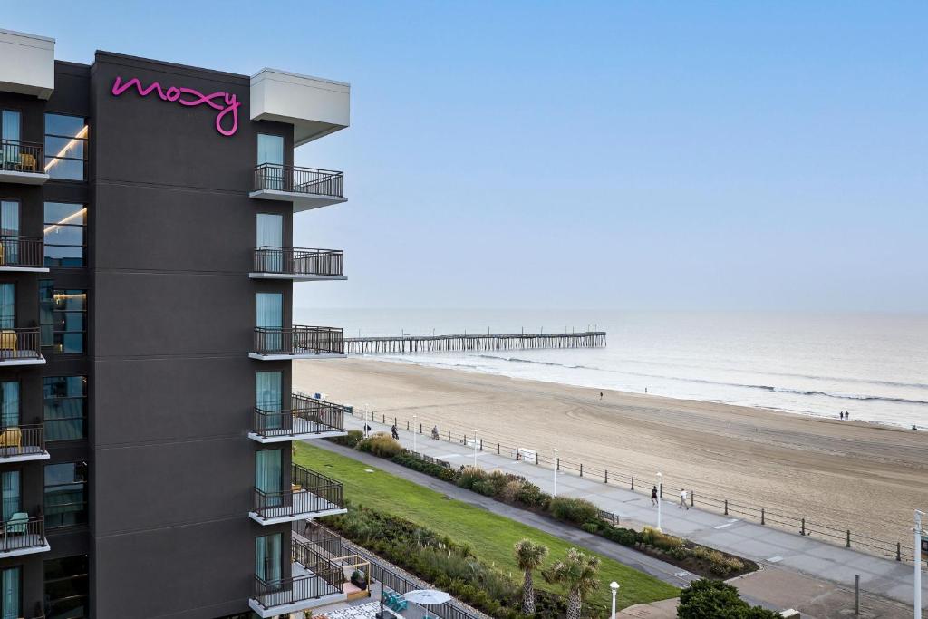 a view of the beach from the balcony of a building at Moxy Virginia Beach Oceanfront in Virginia Beach