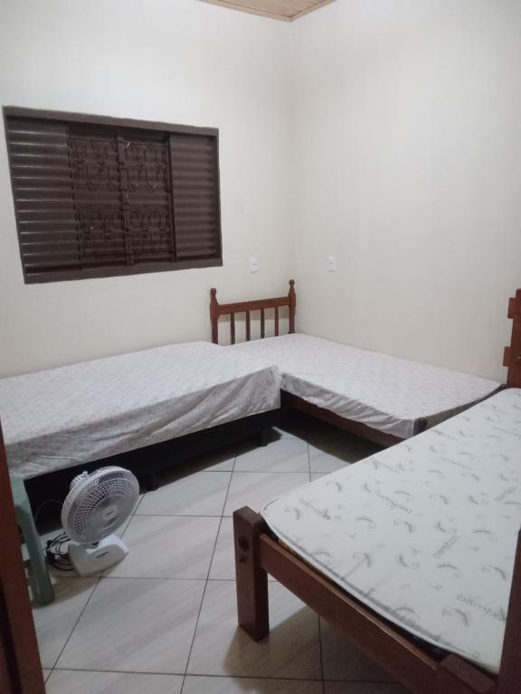 Habitación con 2 camas individuales y ventilador. en Casa para temporada en Pirenópolis