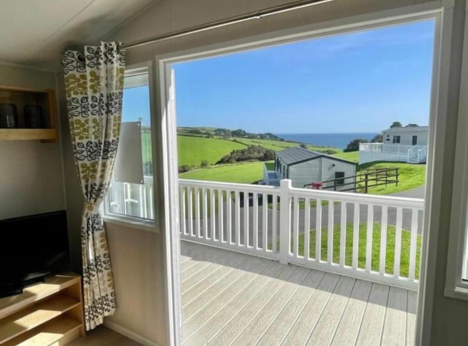 a sliding glass door with a view of a porch at Talland view. Polperro in Looe