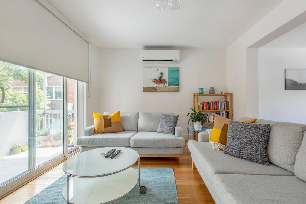 uma sala de estar com um sofá e uma mesa em Breezy East - A Light-filled Family Retreat em Melbourne