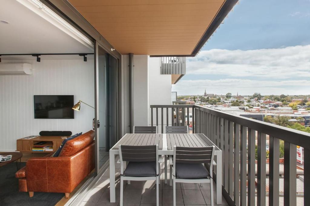 een balkon met een tafel en stoelen en een bank bij Smith Street Crossing - Central City-view Serenity in Melbourne