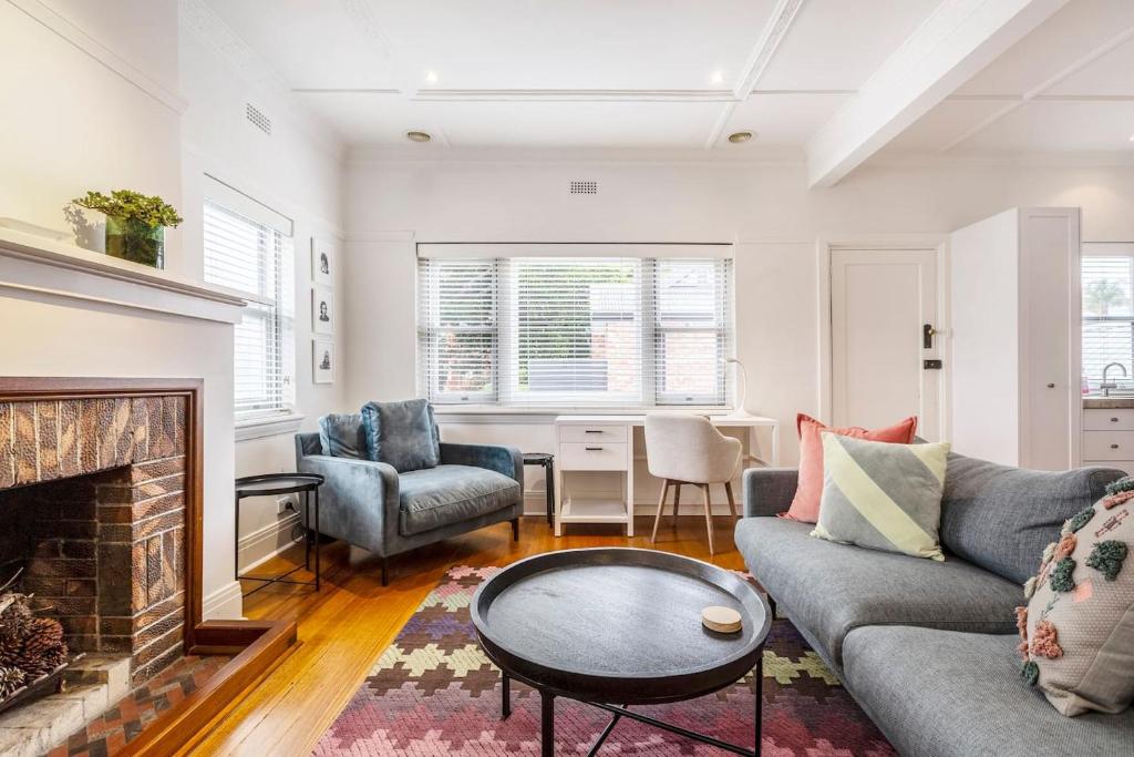 a living room with a couch and a fireplace at Tranquil Inner-east Haven Moments from High Street in Melbourne