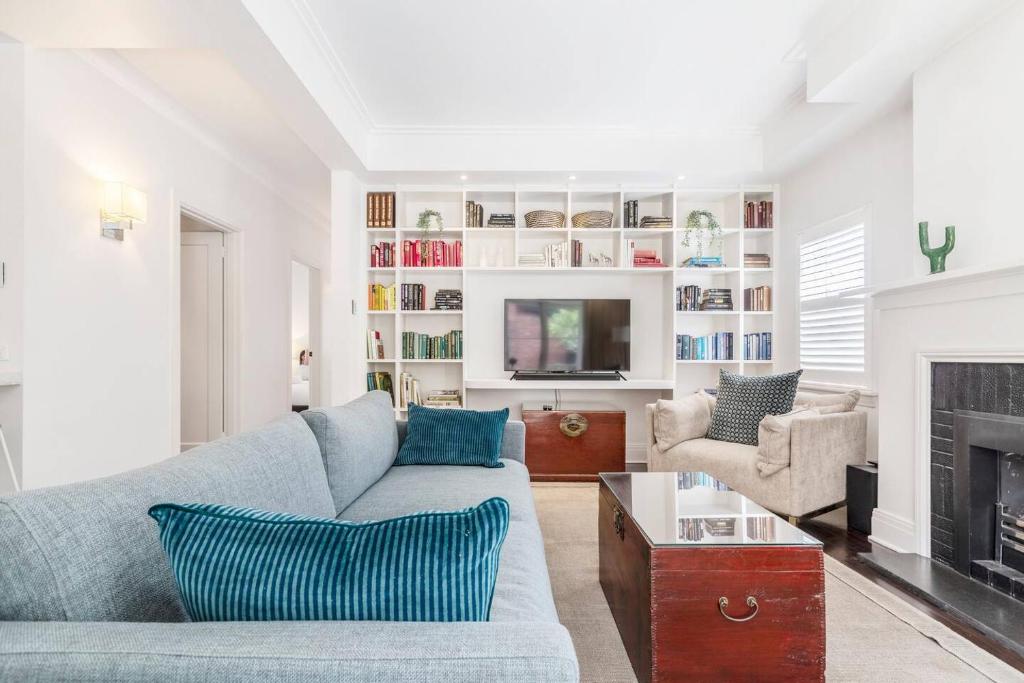 un salon avec un canapé et une cheminée dans l'établissement 'The Chatsworth' Chic Urban Living near High St, à Melbourne