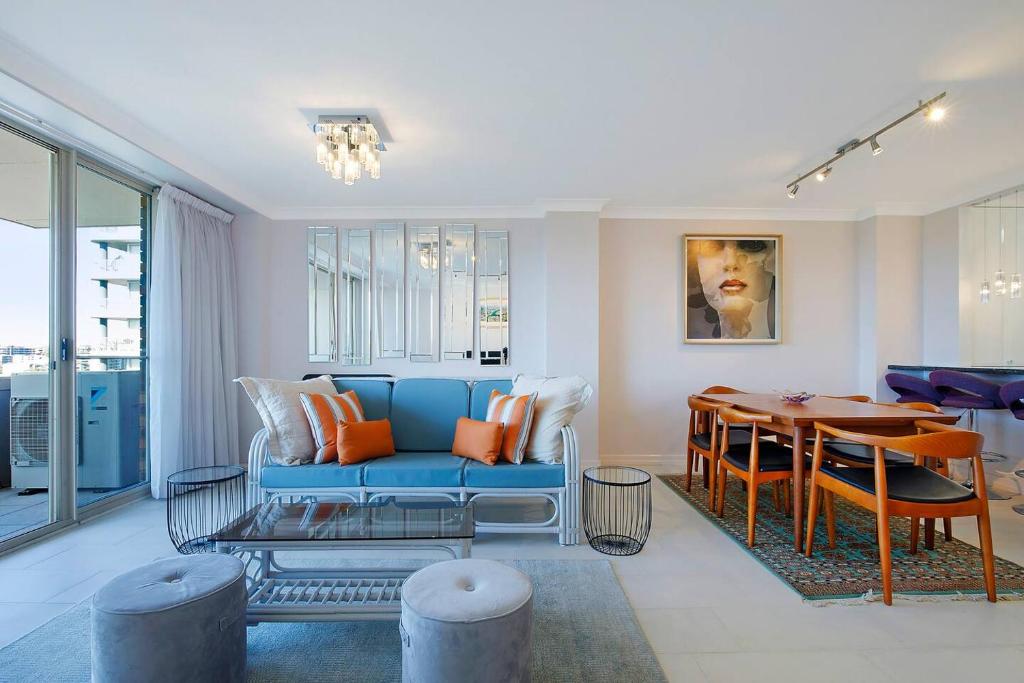 a living room with a blue couch and a table at 'Riverside Terrace' Inner-city Retro-chic with Pool in Brisbane