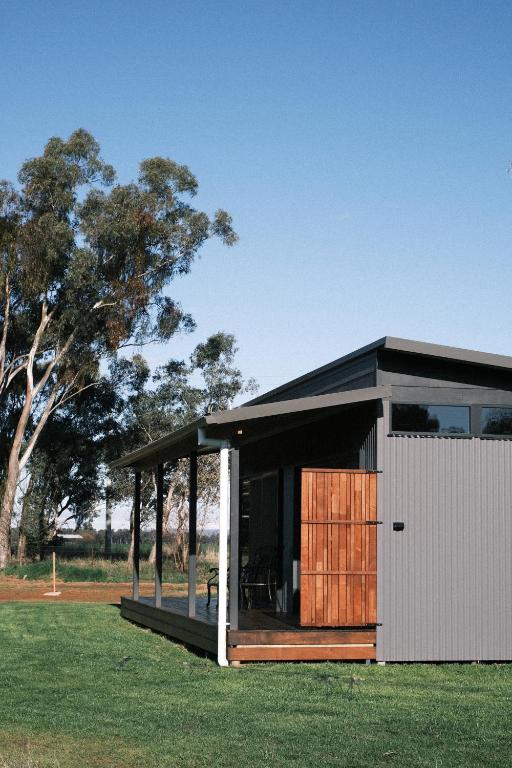 a small house with a black roof on a grass field at Buller Wines in Rutherglen