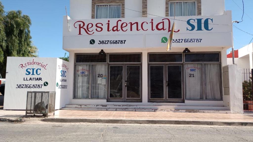 un bâtiment blanc avec un panneau indiquant un restaurant dans l'établissement RESIDENCIAL SIC, à Aimogasta