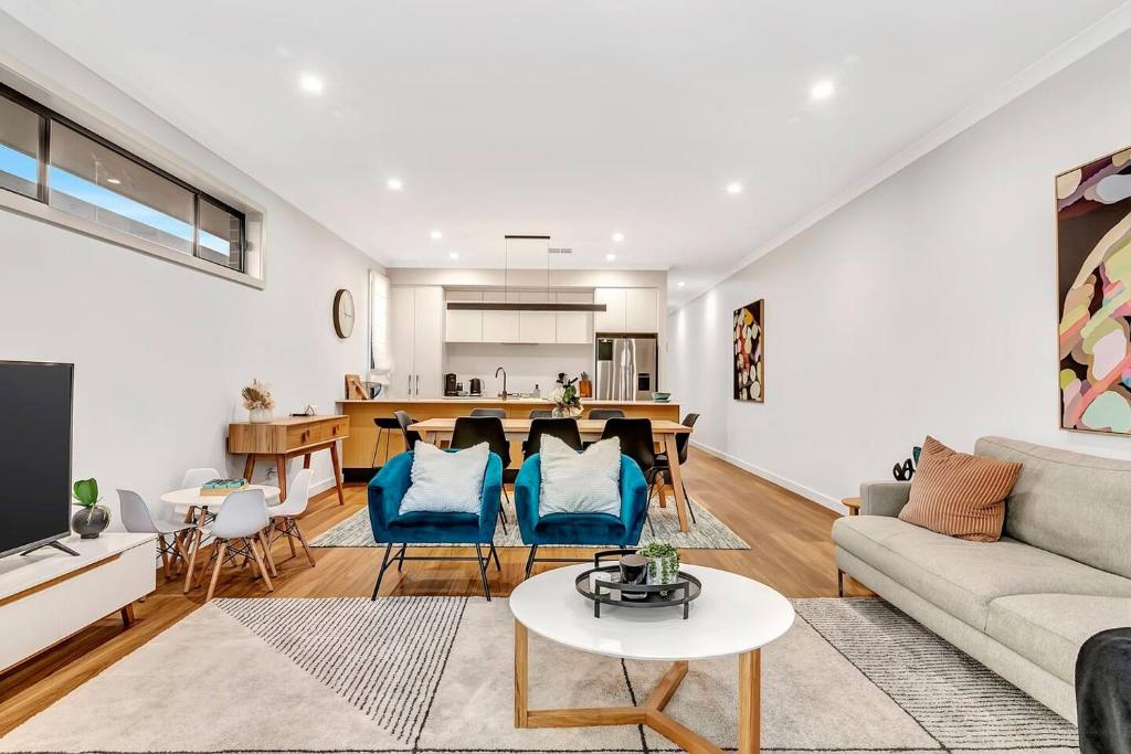 a living room with a couch and a table at 'Brightly Brompton' A Family Delight by the Park in Bowden