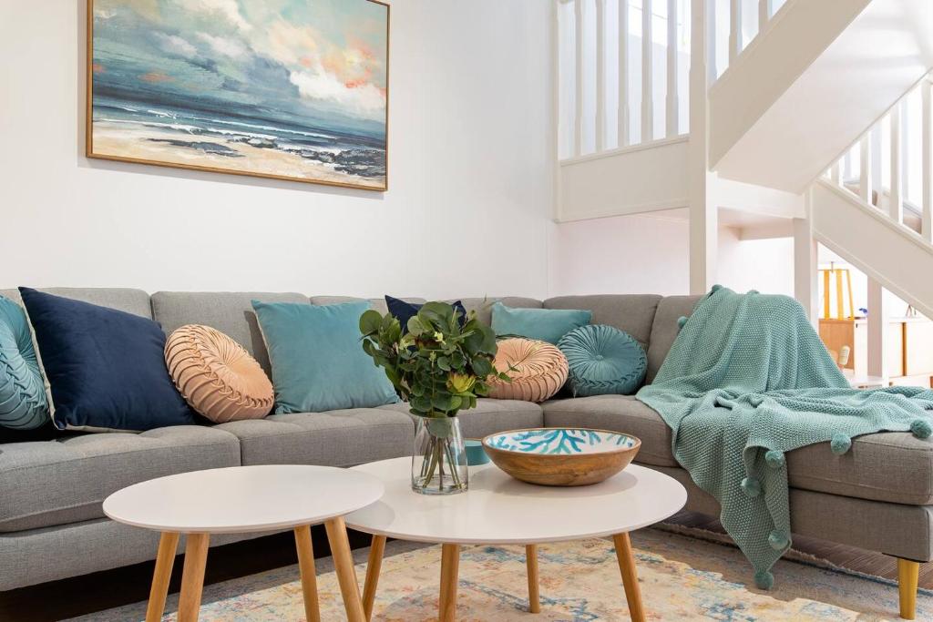 ein Wohnzimmer mit einer Couch und zwei Tischen in der Unterkunft Colley's Nest - Family-friendly Townhouse with Patio in Adelaide