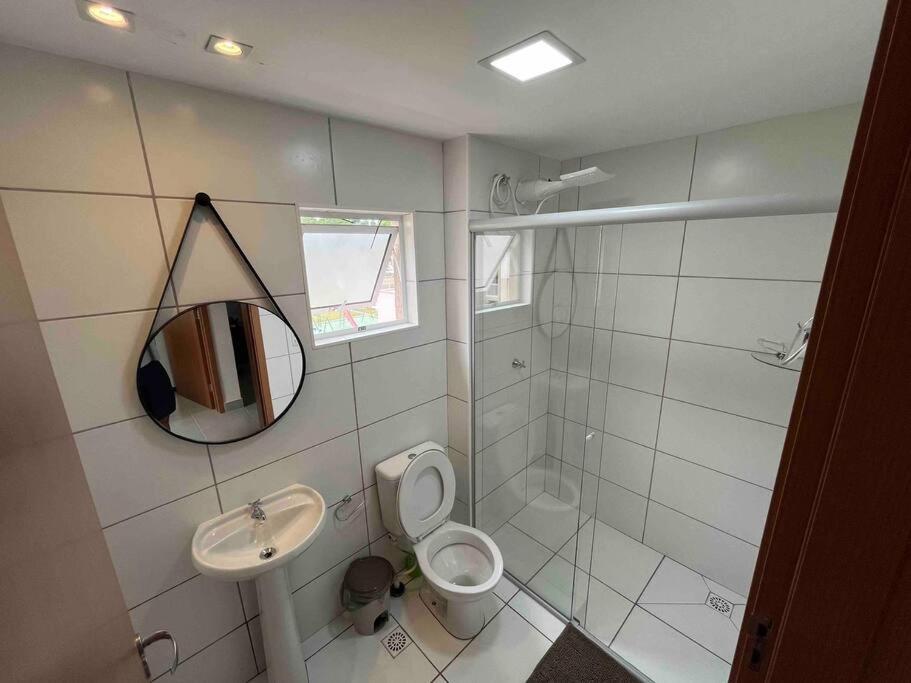 a bathroom with a sink and a toilet and a mirror at Apartamento 2 quartos in Goiânia