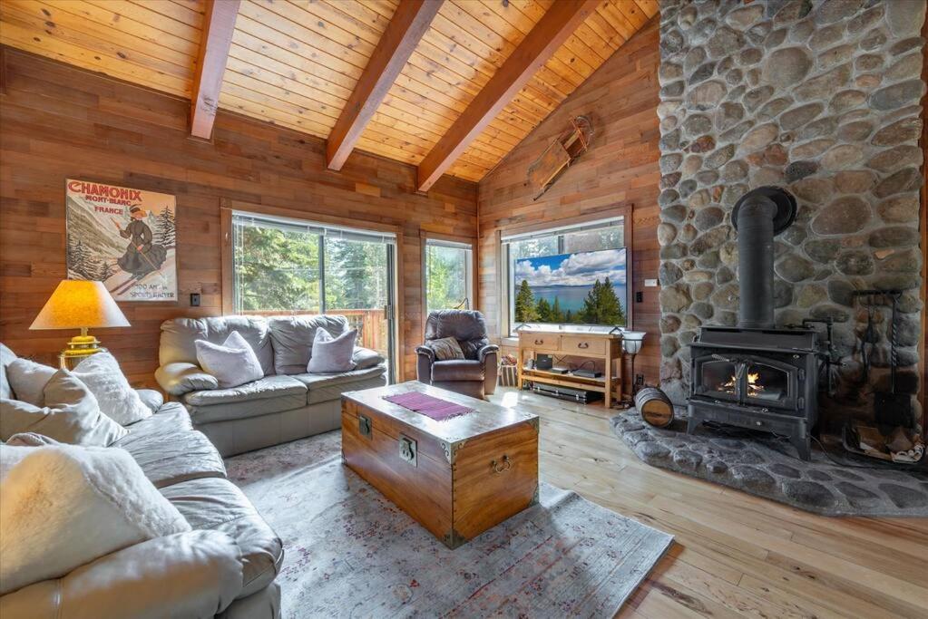 a living room with a stone fireplace in a cabin at Cozy Home with Lake Views Decks Hot-Tub Walk to Private HOA Beach in 5 min in Tahoe City
