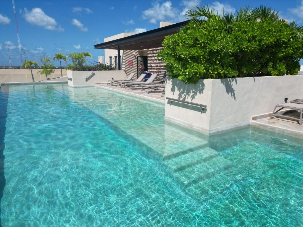 einen Pool mit blauem Wasser vor einem Haus in der Unterkunft Syrena Luxury Caribbean in Playa del Carmen