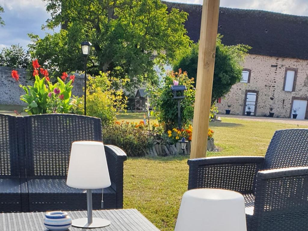 einen Tisch und Stühle auf einer Terrasse mit Blumen in der Unterkunft Gîte Belhomert-Guéhouville, 4 pièces, 6 personnes - FR-1-581-113 in Belhomert-Guéhouville