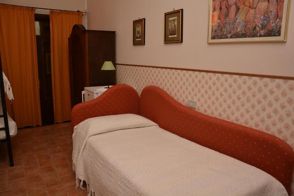 a bed in a room with a red head board at Il Borgo Agriturismo in Ferentillo
