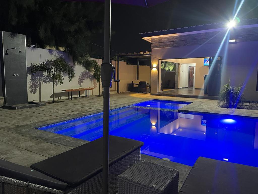 a swimming pool at night with a house at Meanwood Place Apartments in Lusaka