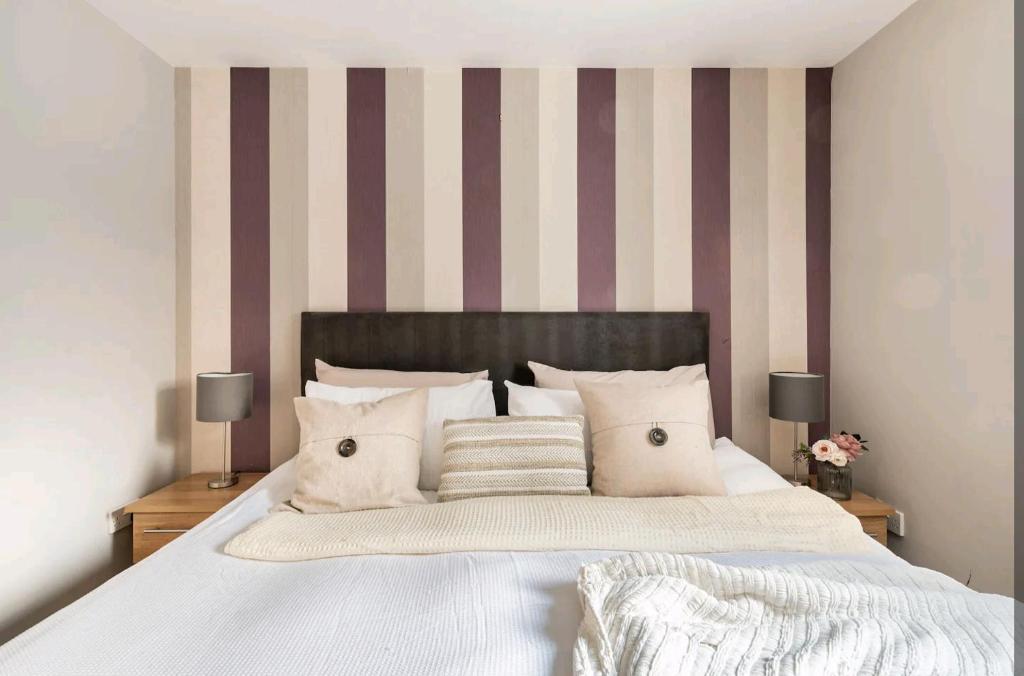 a bedroom with a large bed with striped walls at King size room in well decorated flat in Edinburgh