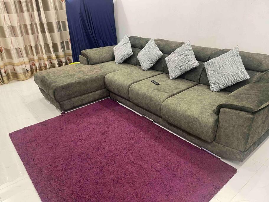 - un canapé dans le salon avec un tapis violet dans l'établissement Bahtek Home with pool & private parking, à Ampang