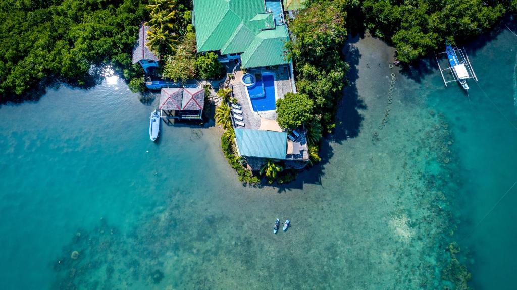 an aerial view of a house on an island in the water at Edgewater Dive & Spa Resort in Puerto Galera