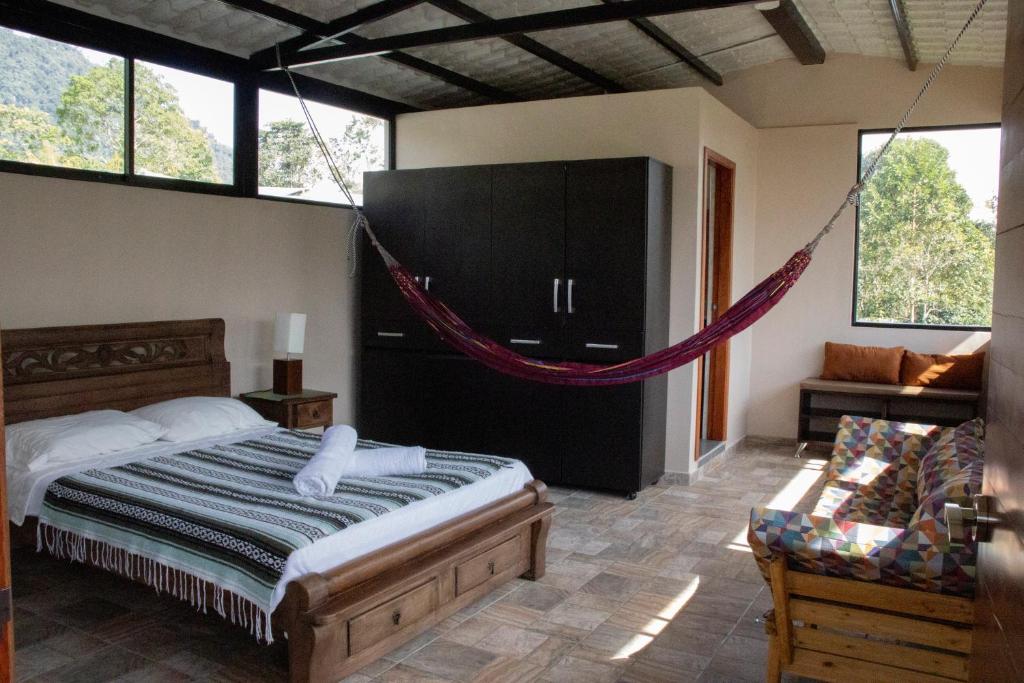 a bedroom with a bed with a hammock in it at Bio-Hotel entre café, bosque y montañas in Cachipay