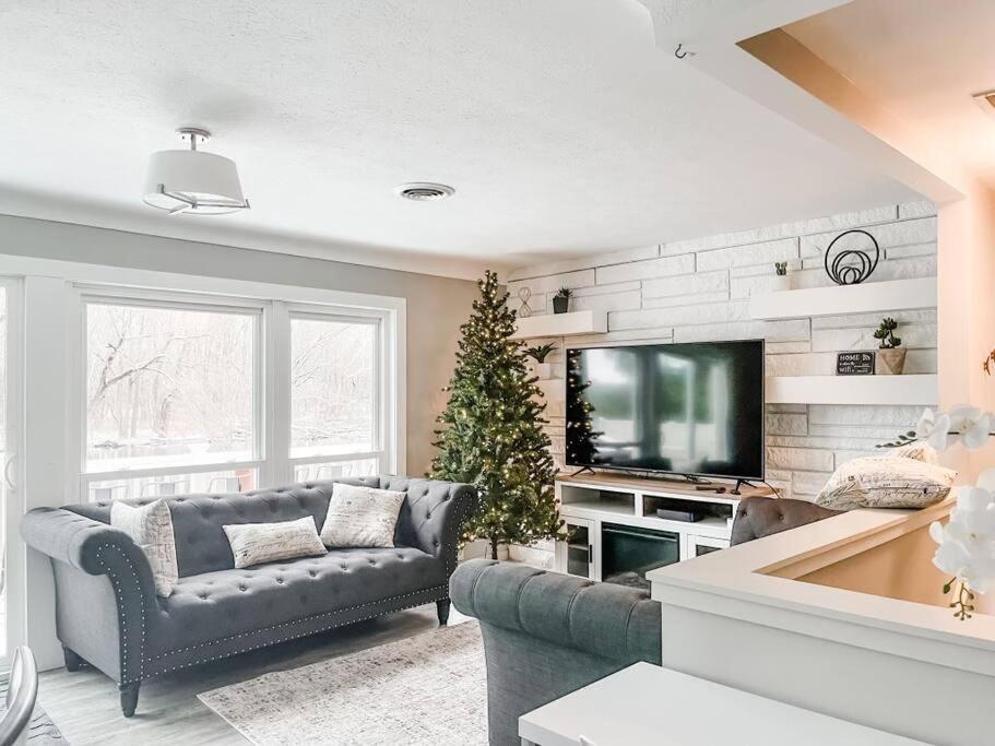a living room with a couch and a christmas tree at Arrowhead Riverfront Kayaks/Patio 30 Min to ND! in Bristol