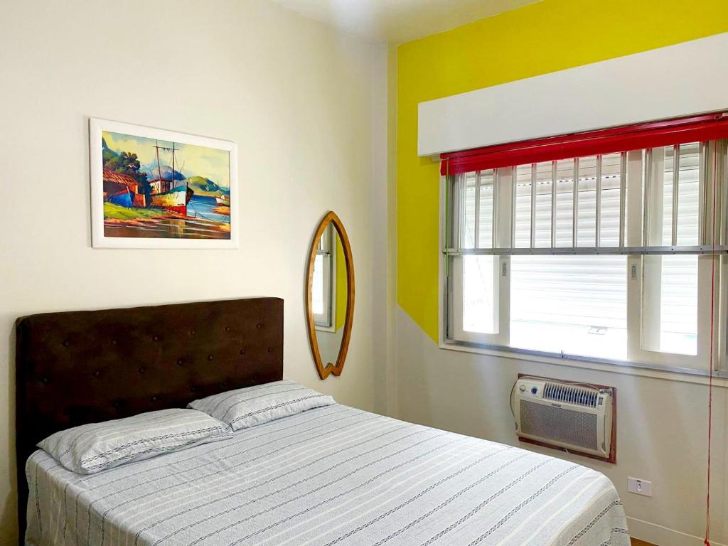 um quarto com uma cama e uma janela em Apartamento Messi Assú Praia dos Milionários em São Vicente