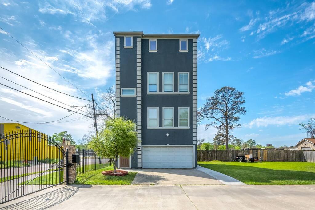 a black house with a white garage at Gorgeous Home w/ Amazing View of Houston Skyline in Houston