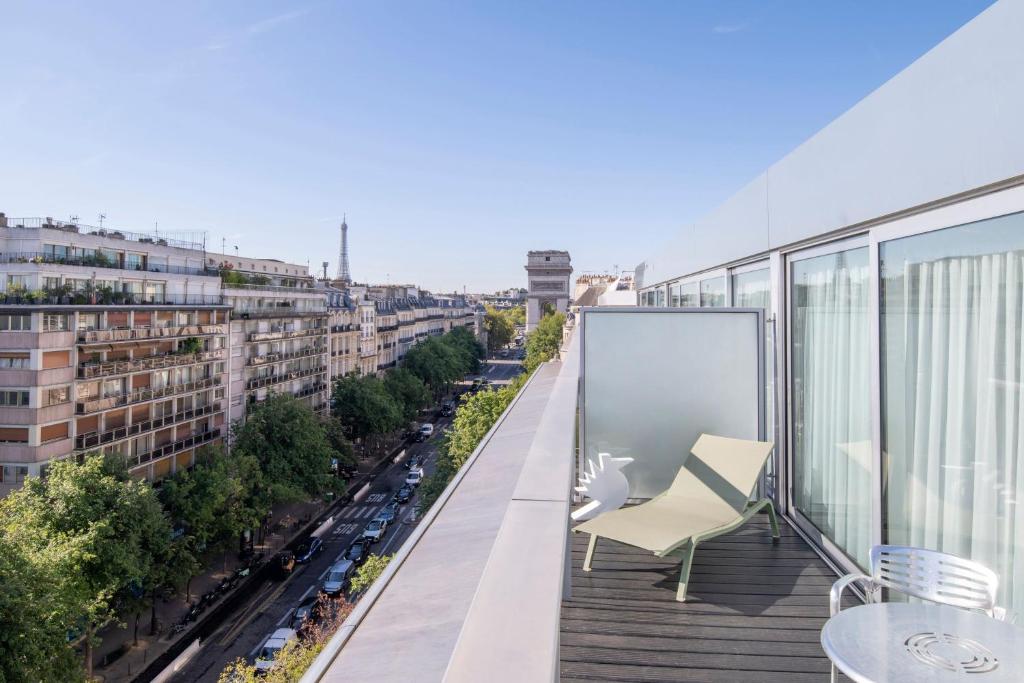 a balcony with chairs and a view of a city at Renaissance Paris Arc de Triomphe Hotel in Paris