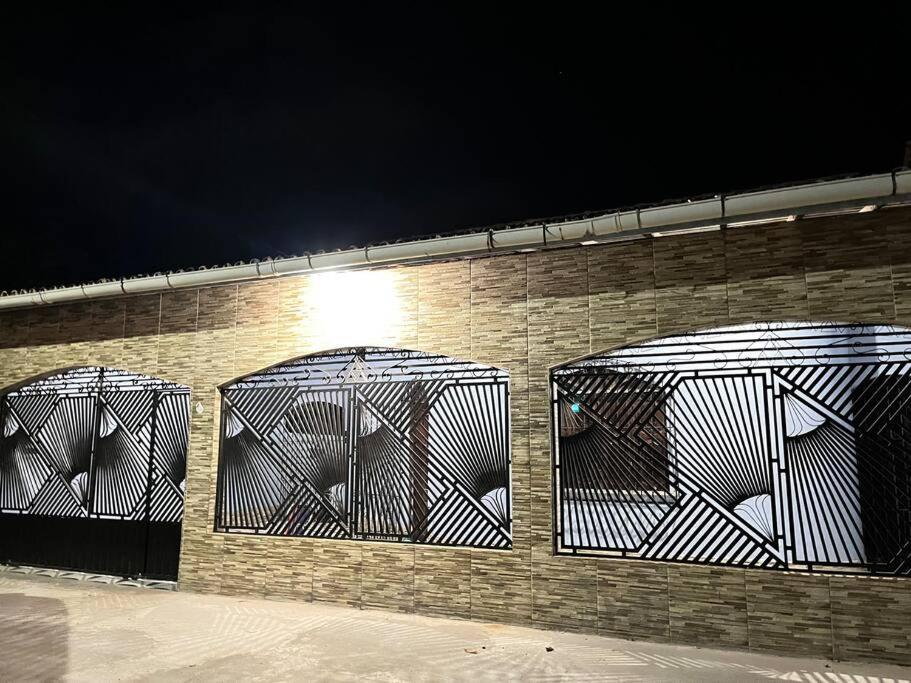 cuatro jaulas en una pared de ladrillo por la noche en Casa para família e amigos, en Soure