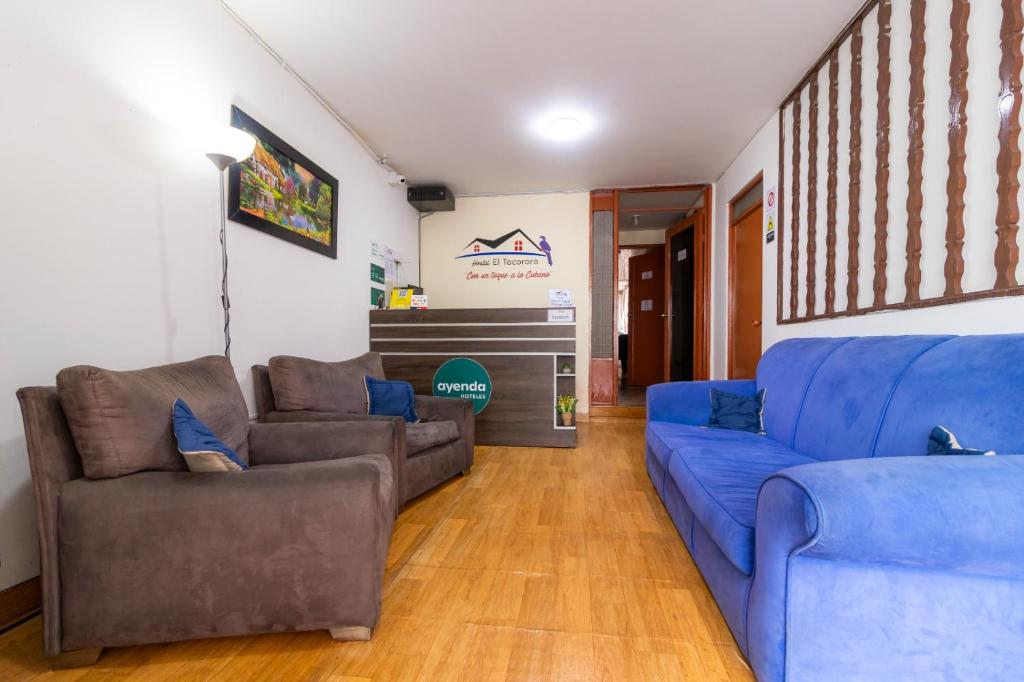 sala de estar con 2 sofás y sofá azul en Ayenda Hostal El Tocororo, en Bogotá