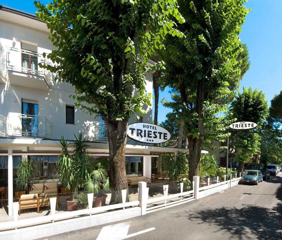 チェルヴィアにあるHotel Triesteの建物の前に2本の木があるホテル