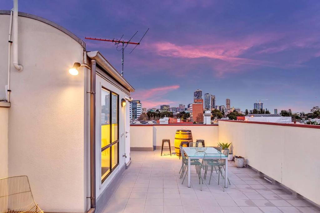 a patio with a table and chairs on a balcony at Stellar - Spacious Rooftop Dreamscape in Adelaide in Rose Park