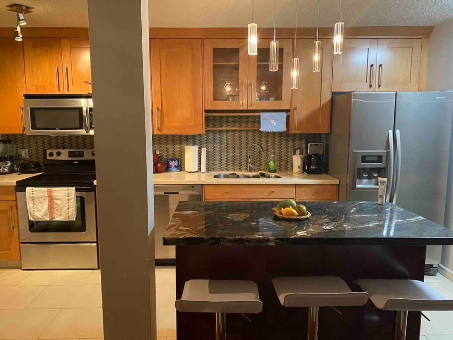a kitchen with wooden cabinets and a granite counter top at Beautiful two bedroom apartment. in Calgary