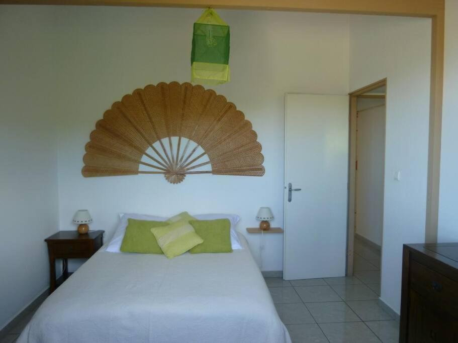 - une chambre avec un lit et un ventilateur mural en bois dans l'établissement TAMPON - Villa au calme,Vue Panoramique, SPA,SAUNA, à Le Tampon